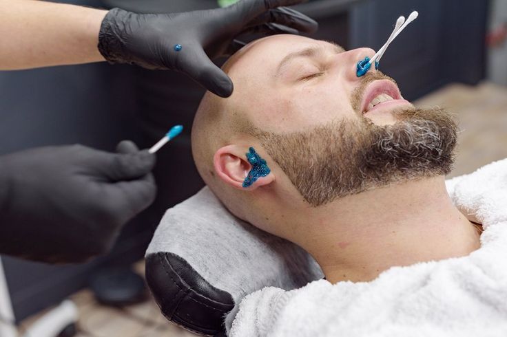 A barber giving a shave with a straight razor